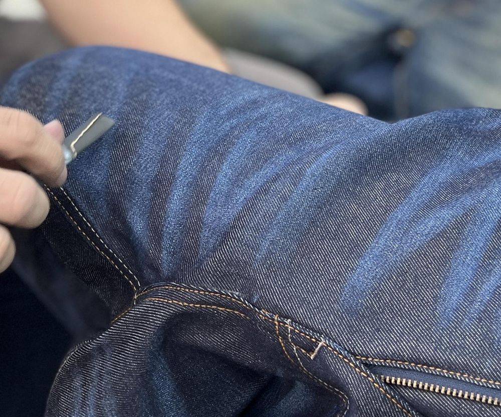 Craftsman sewing premium denim by hand